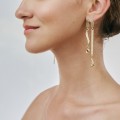 Asymmetrical, gold earrings with a red crystal from the Holos HOK42-3 ORSKA collection